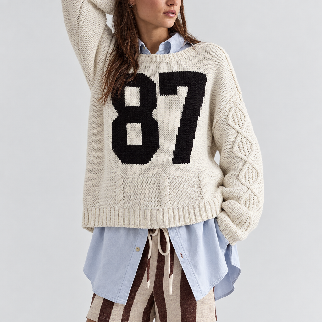 Skyler Varsity 87 Cable Knit Sweater in cream, front view worn over a light blue shirt