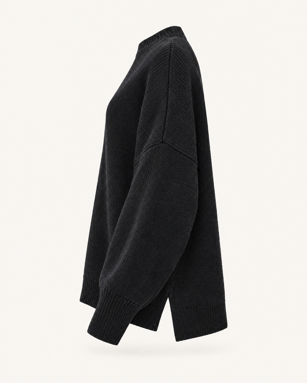 Black oversized knit pullover sweater, side view studio photo